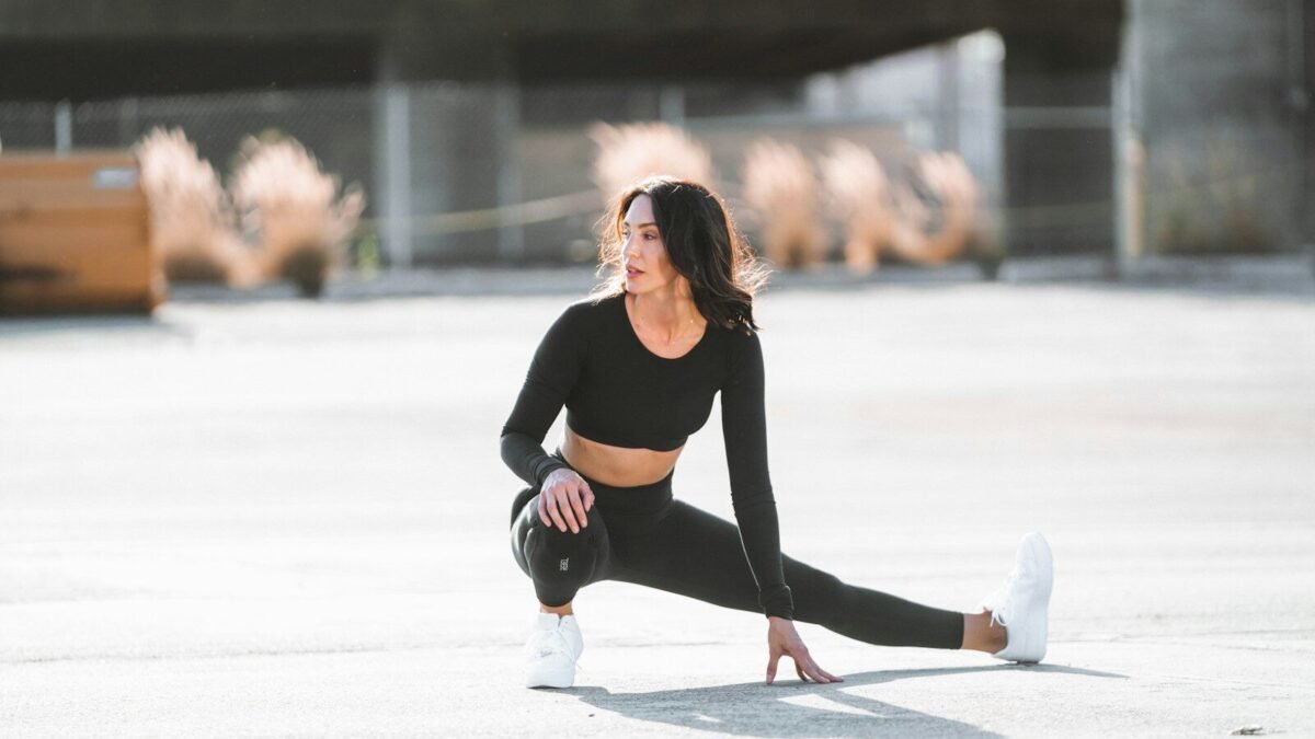 Mulher usando look esportivo preto e segurando tênis, inspiração para look athleisure.