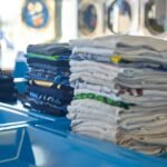 Roupas dobradas sobre uma mesa, ilustrando cuidados e organização de peças fitness.